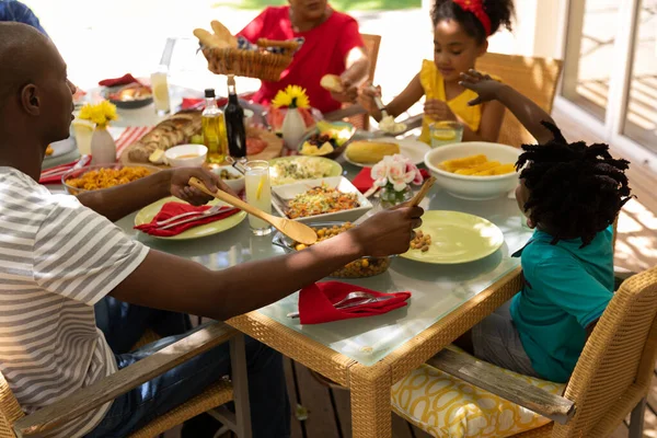 Vista Laterale Una Famiglia Multietnica Multigenerazionale Che Serve Cibo Siede — Foto Stock