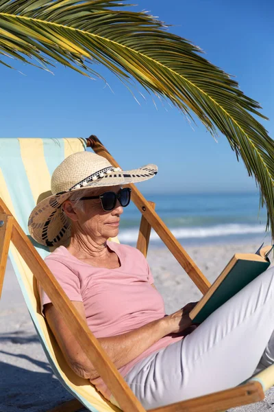 Senior Caucasian Woman Enjoying Time Beach Sitting Deck Chair Reading — Stock Photo, Image