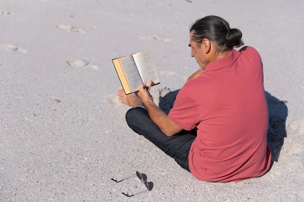 Homem Caucasiano Sênior Aproveitando Tempo Praia Sentado Areia Lendo Livro — Fotografia de Stock