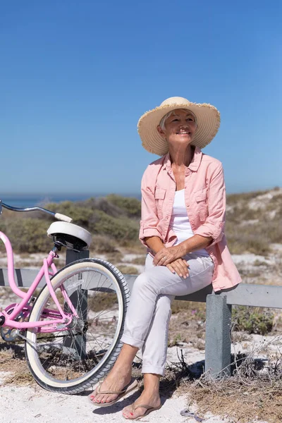 Senior Kaukasiska Kvinna Njuter Tid Stranden Sitter Barriär Med Cykel — Stockfoto