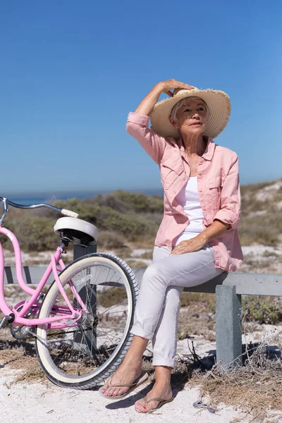 나이가 여자는 해변에서 모자를 자전거 장벽에 즐거운 시간을 보내고 — 스톡 사진
