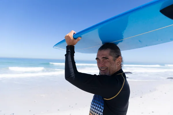 Homem Caucasiano Sênior Desfrutando Tempo Praia Segurando Uma Prancha Surf — Fotografia de Stock