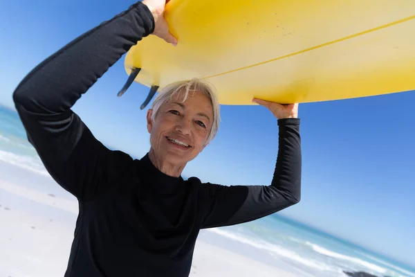 Старшая Белая Женщина Наслаждается Временем Пляже Стоя Держа Доску Серфинга — стоковое фото