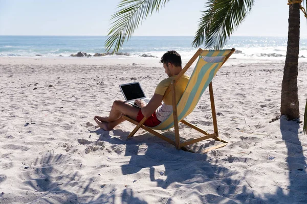 Kaukaski Mężczyzna Bawiący Się Plaży Siedzący Leżaku Korzystający Laptopa — Zdjęcie stockowe