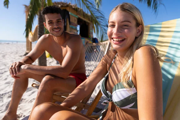 Biała Para Spędzająca Czas Plaży Siedząca Leżakach Patrząca Kamerę Uśmiechnięta — Zdjęcie stockowe