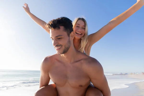 一对白种人夫妇在海滩享受时光 一个男人牵着一个女人的小猪背 — 图库照片