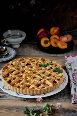 Bir plaka üzerinde ahşap bir masa, kayısı ile bir pasta