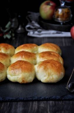 Çörek hamur mayaları, elma ve kuru üzüm ile doldurulmuş. Koyu arka plan, taze elma