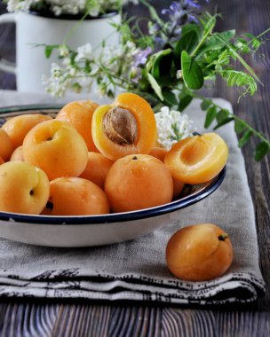 Kemikler ile taze kayısı bir tepside ahşap bir masaya çiçeklerle süslenmiş