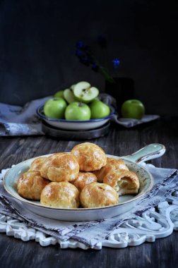 Hamur, pişmiş elma yarısı elma ile buns. Koyu arka plan. Taze yeşil elma ile dekore edilmiş
