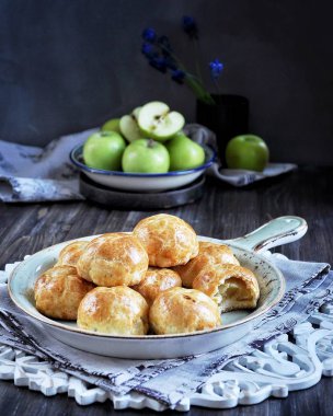 Hamur, pişmiş elma yarısı elma ile buns. Koyu arka plan. Taze yeşil elma ile dekore edilmiş