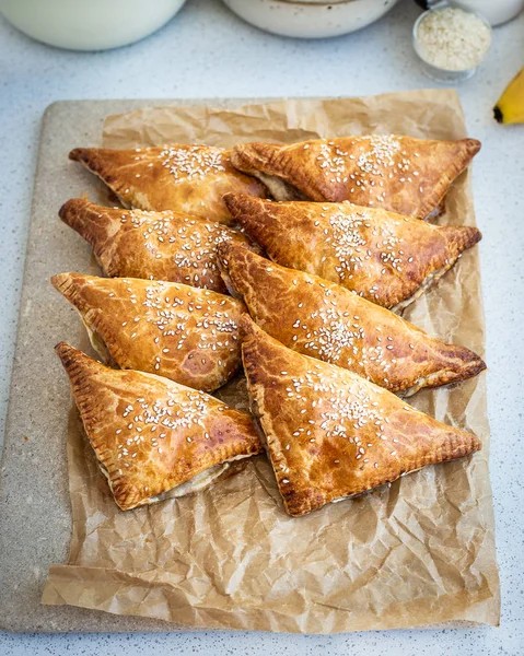 Homemade triangular pies made from ready-made puff pastry with apples