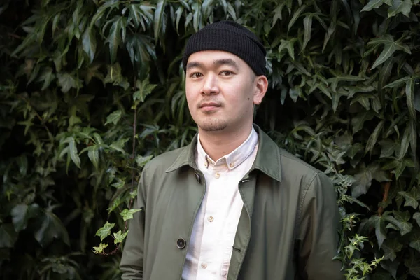 Porträt eines asiatischen Mannes vor ivi bekleidetem Hintergrund — Stockfoto