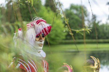 Maskeli ve kırmızı maskeli bir adam kuponunu giyer.