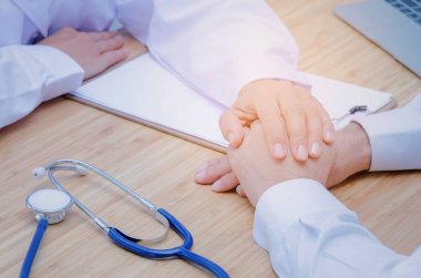 nazik ve dostça genç kadın doktor el güven verici ve dizüstü bilgisayar, Pano ve hastane, Tıbbi Danışma stetoskop erkek hasta, yaş, sağlık ve dikkatle kavramı için gerçek destek veren