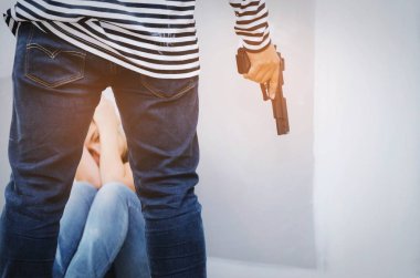 arkadan görünüşü soyguncusu ya da hırsız silahla ve korkarak ve terk edilmiş evde arka planda, tehlikeli suç ve yasadışı şiddet kavramı katta oturan taciz beyaz kız siyah beyaz ceketli