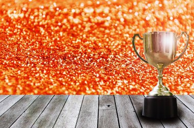 Şampiyon Altın Kupa bardakta portakal glitter doku arka plan, kazanan, başarı ve kutlama kavramı, kopya alanı ürün tanıtımı görüntülenmesi için Resepsiyon ve objektif parlama efektli