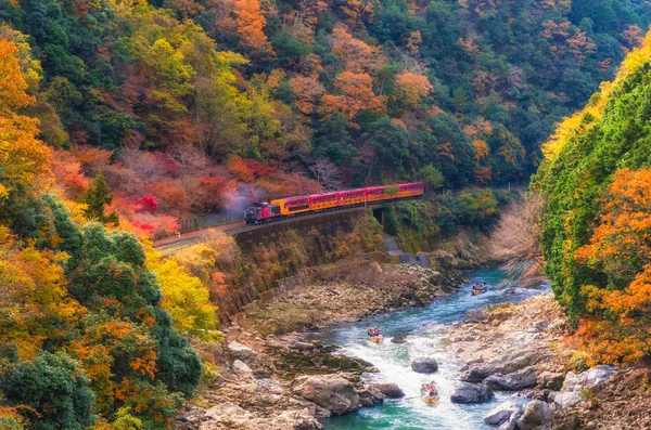Sagano'da doğal demiryolu veya romantik tren Köprüsü ve Arashiyama, Kyoyo, Japonya, sotf odak Nehri'nde tekne ile Sonbahar sezonu güzel dağ manzarası