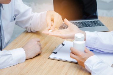 nazik ve dostça genç kadın doktor dizüstü bilgisayar ve Pano Resepsiyon hastane, eczane, yaş, tıp, sağlık ve dikkatle kavramı üzerinde olan orta yaşlı adam hastaya ilaç vererek