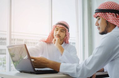 masa ofis, yeni proje dizüstü bilgisayar ile tebrik tanıtım ve paylaşım fikri gösterilen iki genç Arap iş adamı iş arkadaşınız, başarılı, ortaklık, ekip çalışması, pozitif kavramı