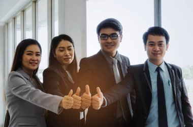 Orta yaş üst düzey Asya iş adamları grubu gösteren başparmak olarak birlikte office, başarılı oturum gibi takım mı, destek, Toplantı, ortağı, ekip çalışması, topluluk, bağlantı kavramı, seçici odak