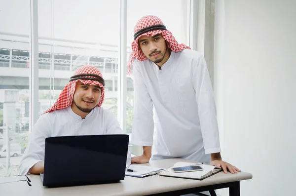 two young Arabian business man working together and share idea of greeting new project with laptop computer on desk in office, corporate, successful, partnership, teamwork and positive concept