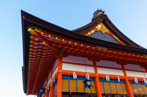 close up view of red beautiful buddhist temple building at Fushimi Inari Shrine is the famous tourist attraction temple in Kyoto, Japan with bright blue sky at the moring in autumn