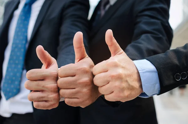 close up of hand group of handsome business people team in suit showing thumbs up as like sign together in the city, successful, support, meeting, partner, teamwork, community and connection concept