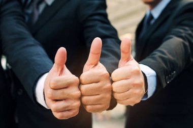 yakışıklı iş insanlar takım elbiseli başparmak olarak birlikte şehir, başarılı, destek, Toplantı, ortağı, ekip çalışması, toplum ve bağlantı kavramı imzalamak gibi göstermek yukarıya el grubunun yakın çekim