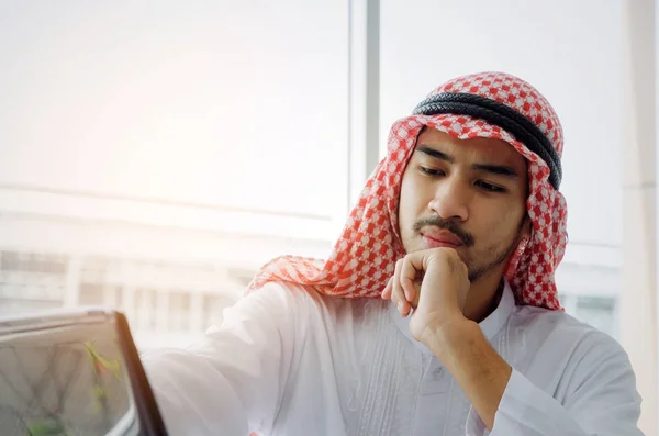 young Arabian business man developing a new idea and working with laptop computer on desk at the morning in home office, successful, financial, business technology and investment concept