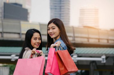 iki güzel neşeli Asya genç kadınla birlikte yaşayan yürüyüş poşetler, kış satış, siyah Cuma, promosyon, özel teklif satış, insanlar, ödeme ve online kavramı alışveriş