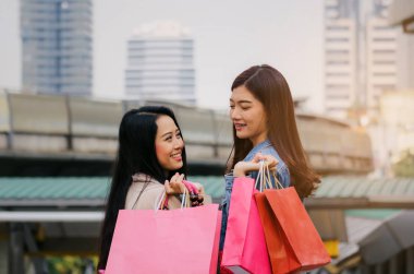 iki güzel neşeli Asya genç kadınla birlikte yaşayan yürüyüş poşetler, kış satış, siyah Cuma, promosyon, özel teklif satış, insanlar, ödeme ve online kavramı alışveriş