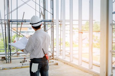 Arkadan Görünüm akıllı mühendis, mimar veya beyaz emniyet kask holding planı proje, başarılı, tebrik başlatmak için iş, sanayi kavram bina inşaat alanı ile teknisyen