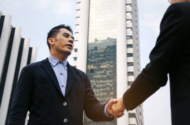 Hoş geldiniz. Anlaşma. bir iş yeni sözleşme görüşme şehir, kutlama, başarı, Toplantı, ortağı, ekip çalışması, toplum ve bağlantı kavramı bitirdikten sonra takım elbise sıkışmasında iki iş adamı