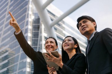 Grup iş adamları yukarı dönük ve ilâ arıyor takım elbiseli mobil tablet birlikte ayakta modern şehir, başarılı, destek, Toplantı, ortağı, ekip çalışması, ağ teknolojisi kavramı ile gelecek