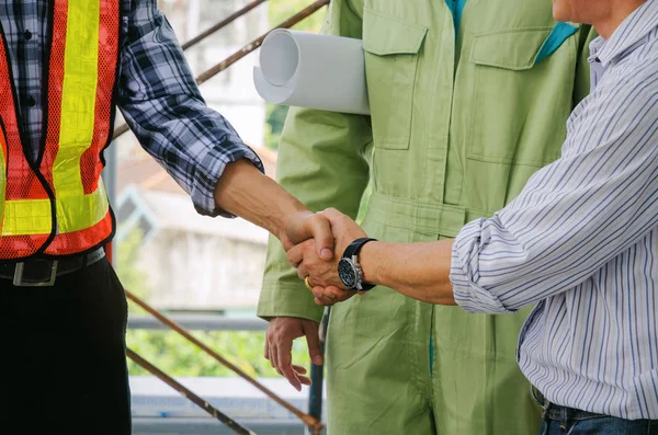 engineer and technician contractor shaking hands after finishing up a business meeting to greeting start up project contract in construction site building, successful, partnership, teamwork concept