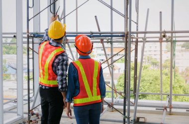 plan proje inşaat sitesi sanayi, endüstri kavramı içinde tebrik başlangıç için bina hakkında planlama mühendisi veya teknisyen erkek ve kadın tutarak mobil radyo kask ile bir kaç telefon