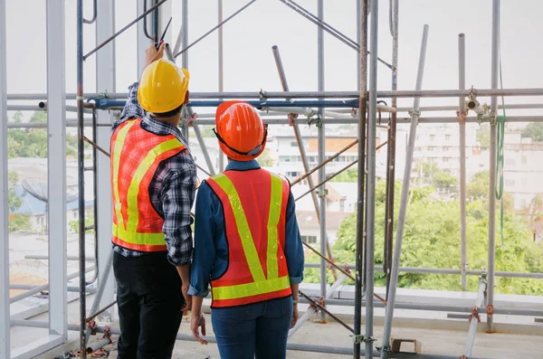 plan proje inşaat sitesi sanayi, endüstri kavramı içinde tebrik başlangıç için bina hakkında planlama mühendisi veya teknisyen erkek ve kadın tutarak mobil radyo kask ile bir kaç telefon