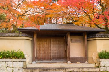 geleneksel Japon tarzı ahşap giriş kapısı veya renkli sonbahar sezonu güzel renkli Japonca akçaağaç bahçede Kyoto, Japonya, kapıya seyahat, doğa, Simgesel Yapı ve arka plan kavramı manzara