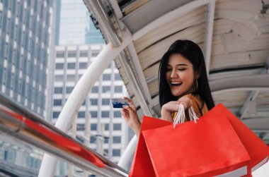 birçok renkli kırmızı alışveriş torbaları ve kredi kartı modern büyük şehirde yürüyüş moda tutan genç güzel kadın, promosyon, özel indirim, yaz Satılık, insanlar, ödeme ve online kavramı alışveriş