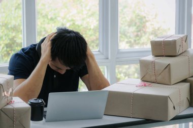 Başlamak yukarıya. Depresif, hayal kırıklığına, vurguladı. Online kavramı alışveriş dizüstü bilgisayar ve teslim ambalaj kutusu masada, evde çalışma office, KOBİ, küçük işletme sahibi çalışma genç Asyalı adam