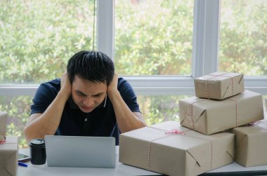 Başlamak yukarıya. Depresif, hayal kırıklığına, vurguladı. Online kavramı alışveriş dizüstü bilgisayar ve teslim ambalaj kutusu masada, evde çalışma office, KOBİ, küçük işletme sahibi çalışma genç Asyalı adam