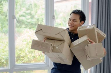 yakışıklı genç Asyalı teslimatçı mutlu müşteri ve birçok ambalaj koli kaldırma yeni siparişten sonra kutu ev ofis, alışveriş online, küçük işletme sahibi, kargo, posta ve nakliye kavramı