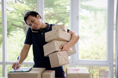 Başlamak yukarıya. genç adam yeni klibi kurulu, cep telefonu ve teslimat parsel kutusu tablo, evde çalışma office, KOBİ, küçük işletme sahibi ile müşteri online kavramı alışveriş siparişinden sonra mutlu