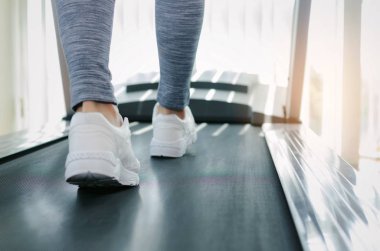 Hareket Bulanıklığı runner kadın fitness spor salonu Merkezi veya sağlık kulübünde güneş ışığı etkisi ile makine treadmill çalışan ayak, vücut geliştirmeci, sağlıklı yaşam, egzersiz fitness, egzersiz, spor eğitim kavramı