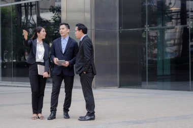 Grup iş adamları finans haberleri ile dizüstü bilgisayar ve cep telefonu birlikte ayakta City hakkında konuşan bilgi uygun, teknoloji, internet, başarılı, ekip çalışması kavramı ağ