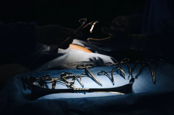 外科医のグループは病院 医療技術 医療がんや病気治療の概念で手術室で作業中のテーブルの上に横たわる手術器具のクローズ アップ — ストック写真