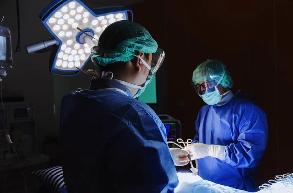 医疗技术 保健癌症 疾病概念的外科医生和助理外科医师送手术器械到手术室抢救病人手上工作 — 图库照片