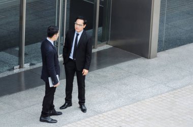 Finans haber birlikte ayakta önünde banka şehir, kutlama, başarı, Toplantı, ortağı, ekip çalışması, topluluk, bağlantı kavramı hakkında bilgi konuşan iki iş genç Asyalı akıllı adam