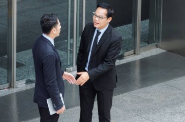 Finans haber birlikte ayakta önünde banka şehir, kutlama, başarı, Toplantı, ortağı, ekip çalışması, topluluk, bağlantı kavramı hakkında bilgi konuşan iki iş genç Asyalı akıllı adam